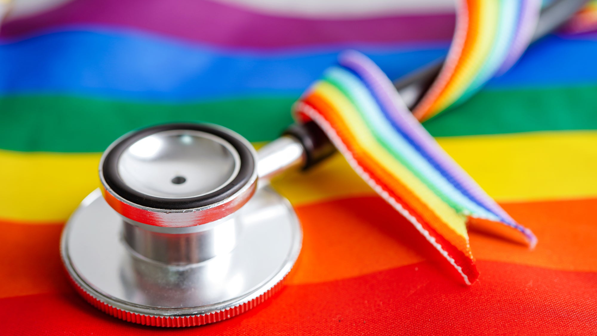 LGBTQ flag, ribbon, and stethoscope