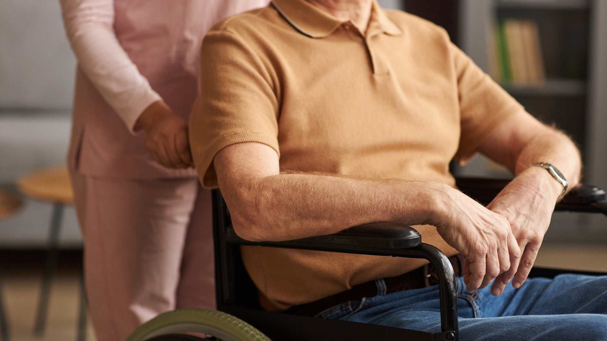 Man in wheelchair with social worker caring for him