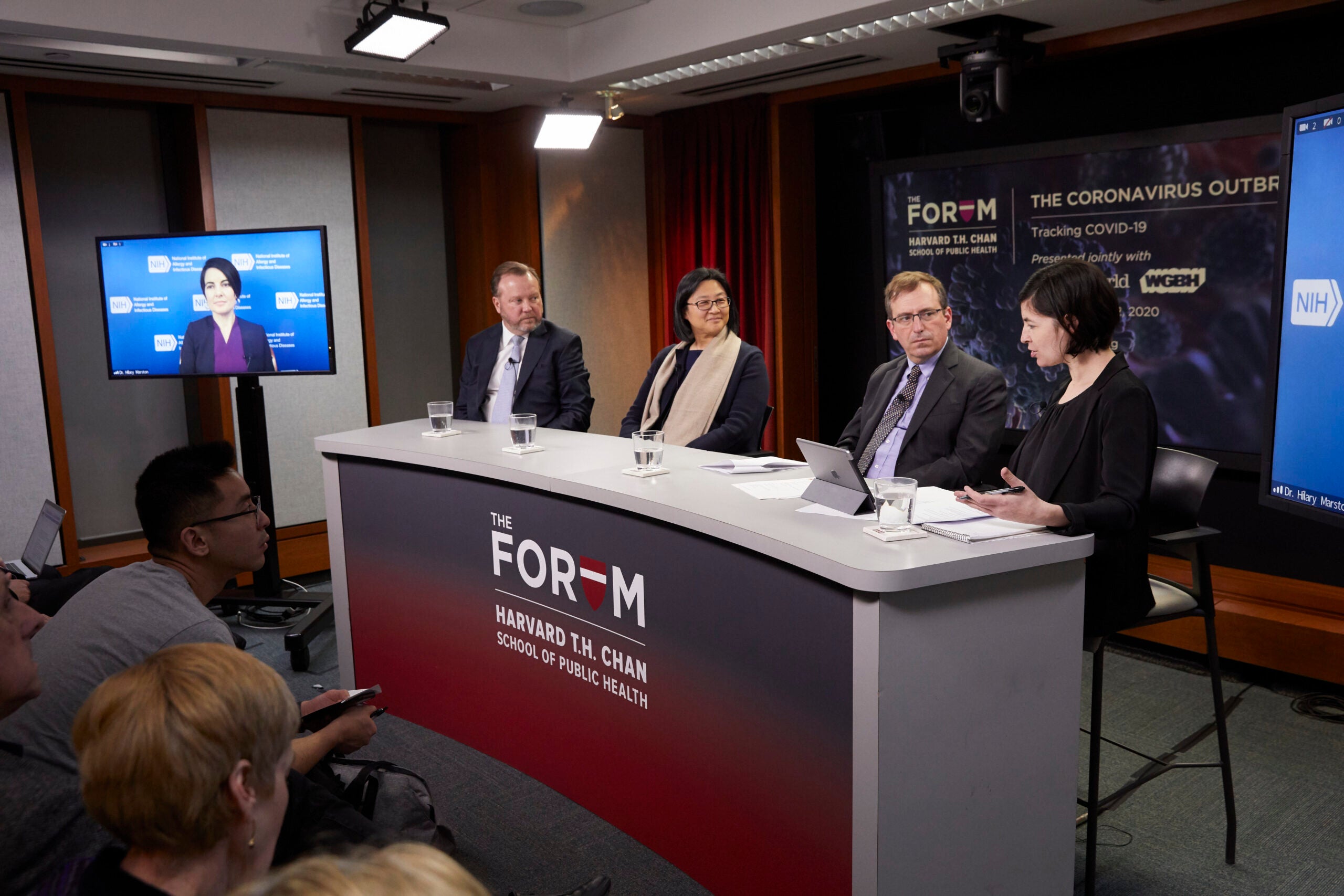 Panel of 4 in a COVID forum seated facing the audience.