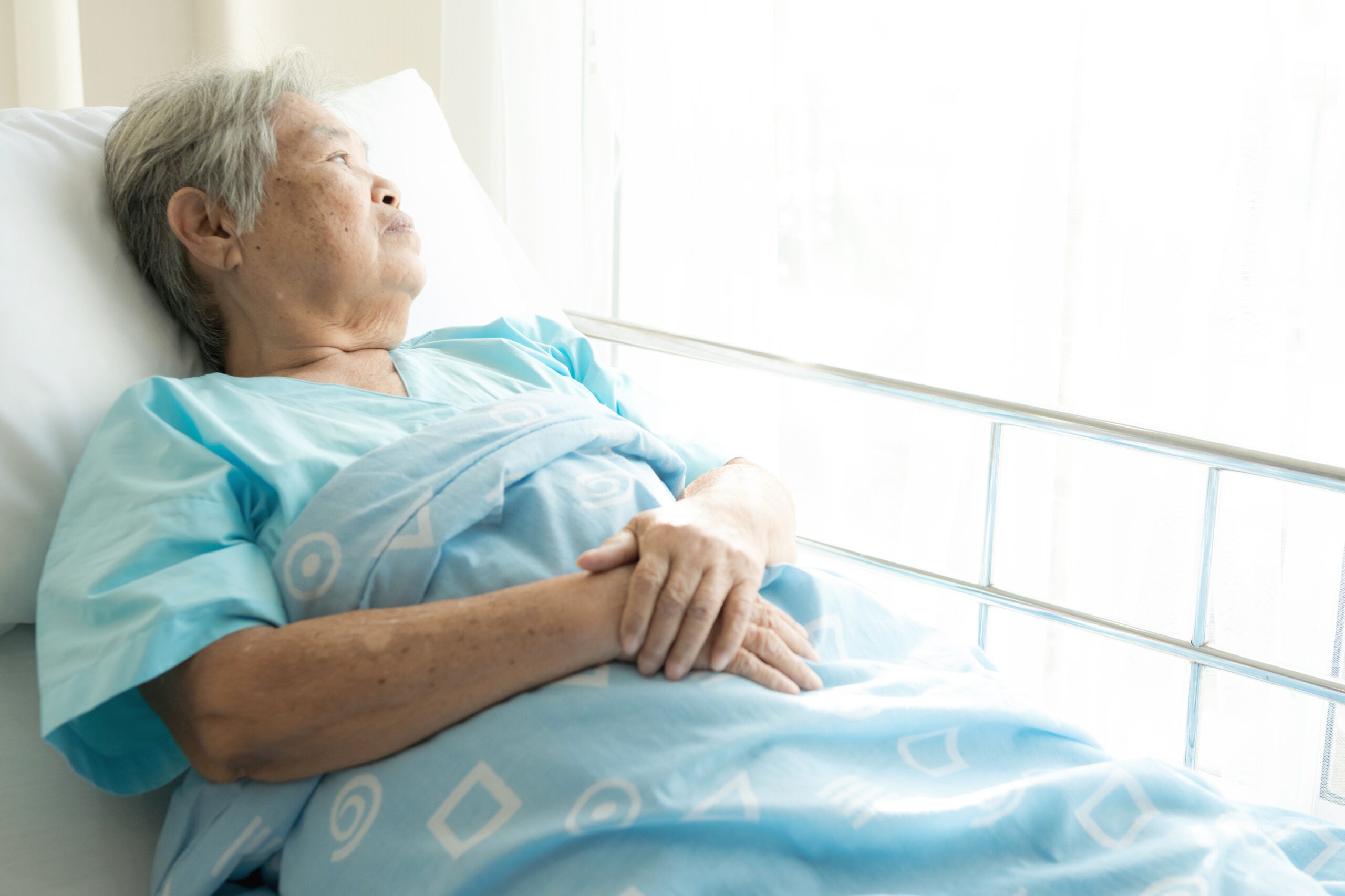 Older woman lying in hospital bed