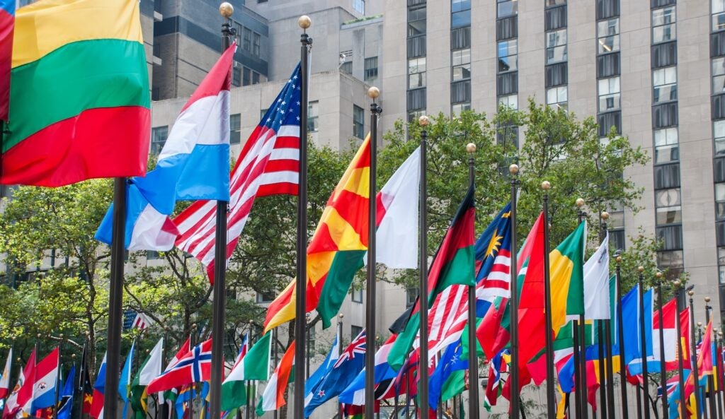 Rows of flags of all nations next to United Nations