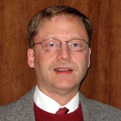 Headshot of Richard Pollack. He is wearing glasses and a suit.