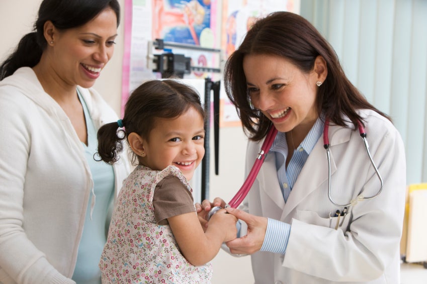 Doctor doing a check-up with a little girl and her mother