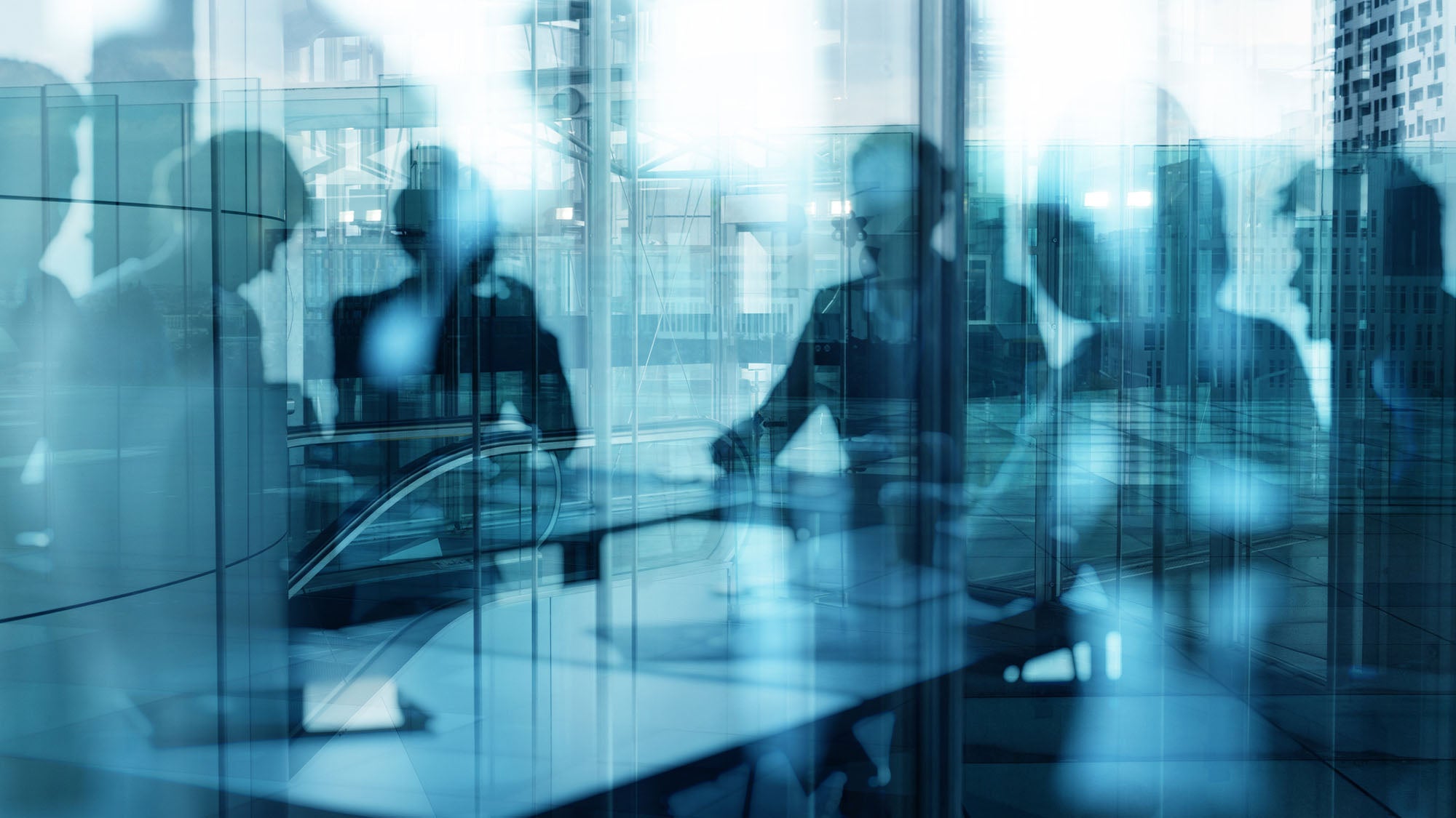 Silhouettes of people holding a meeting, seated around a table.