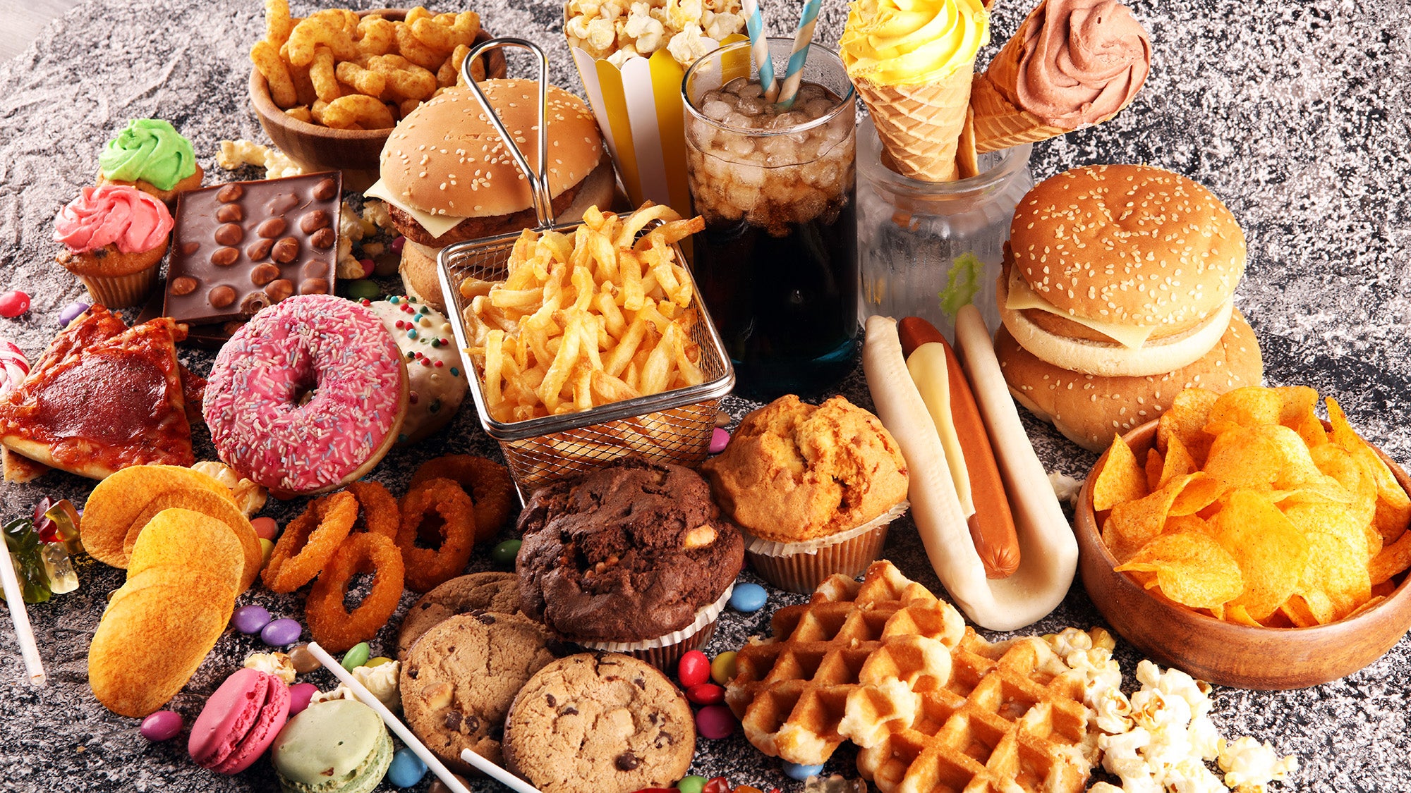 Unhealthy foods—burgers, hot dogs, fries, waffles, doughnuts, cookies, potato chips, etc.