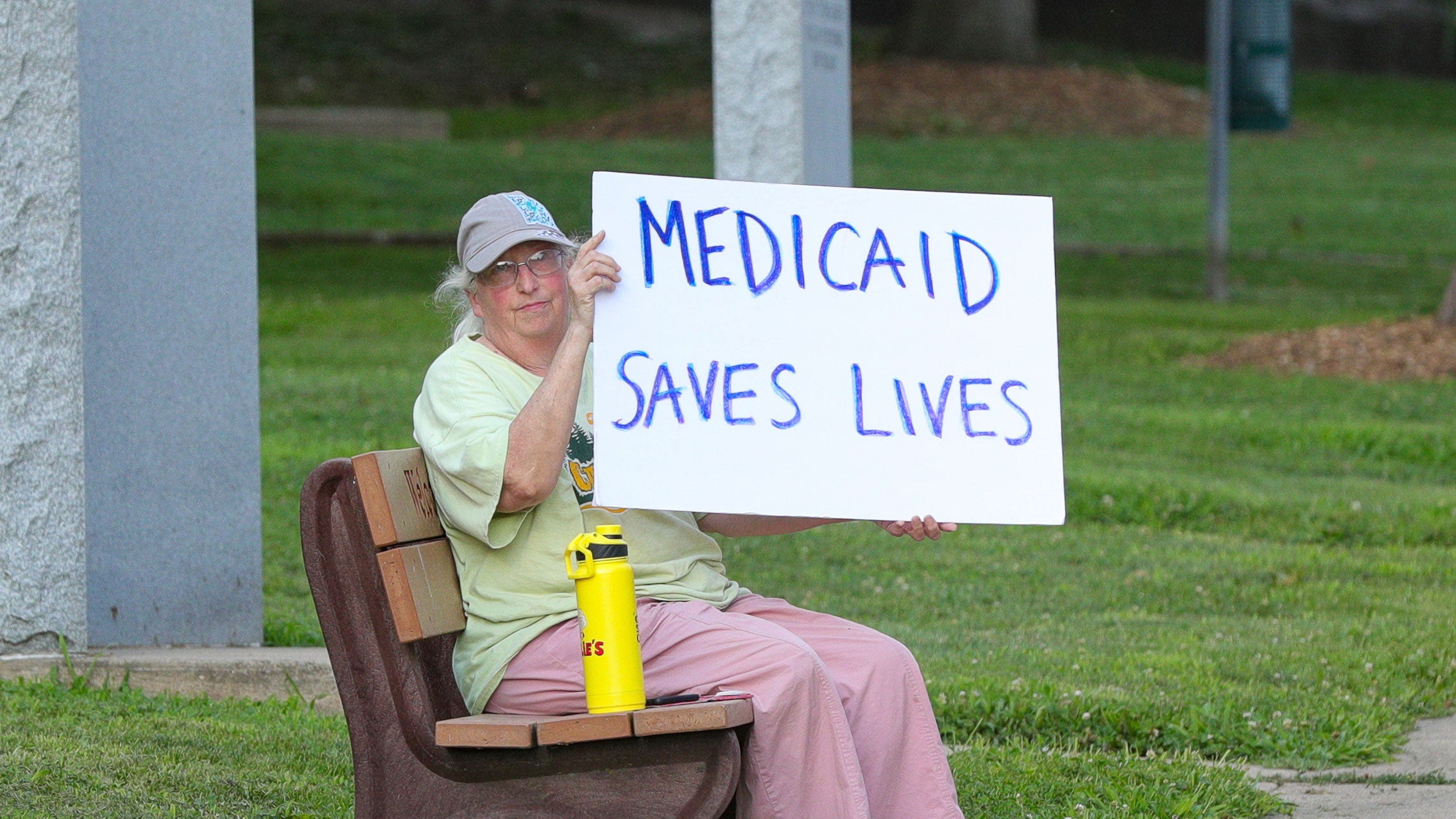 Woman holds placard during "Good Trouble Lives On: Dying for Healthcare" rally, Danville, PA, July 2025