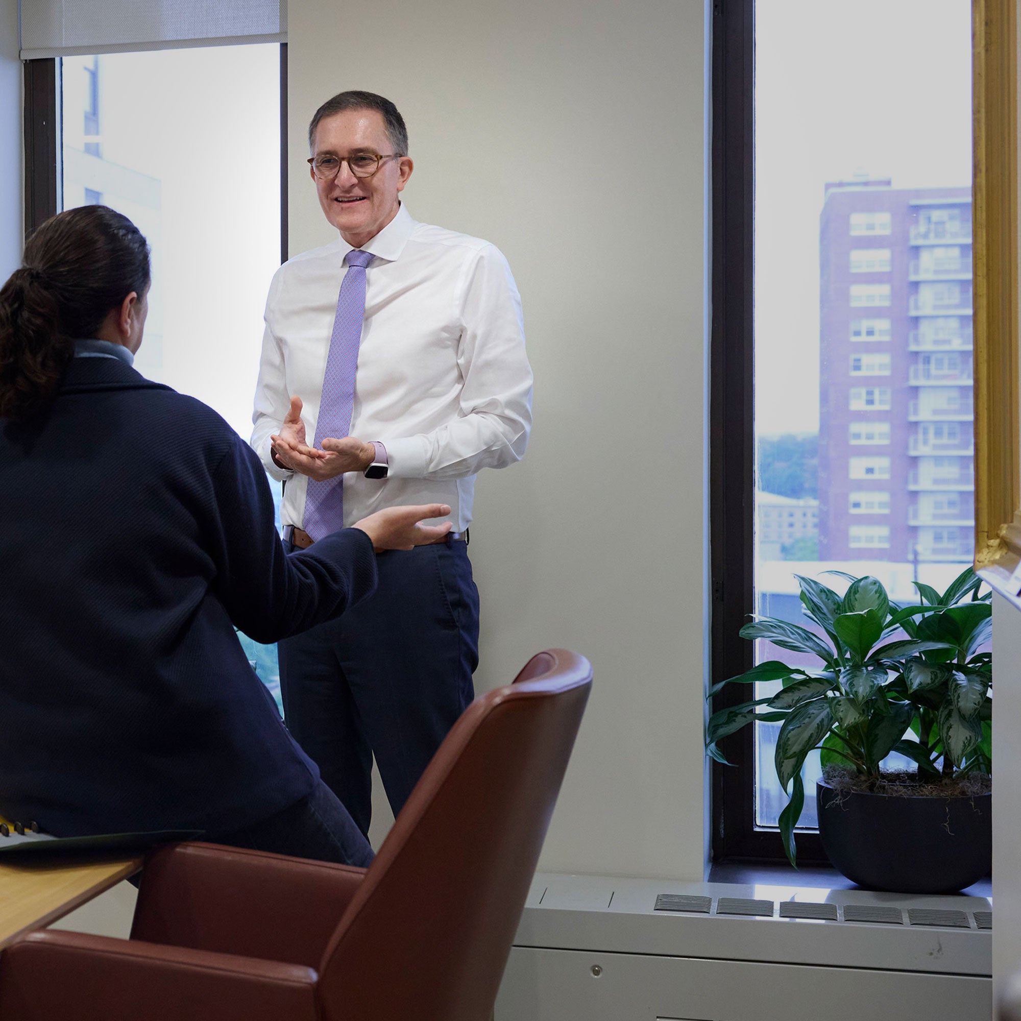 Dean Baccarelli speaking with a colleague in a conference room
