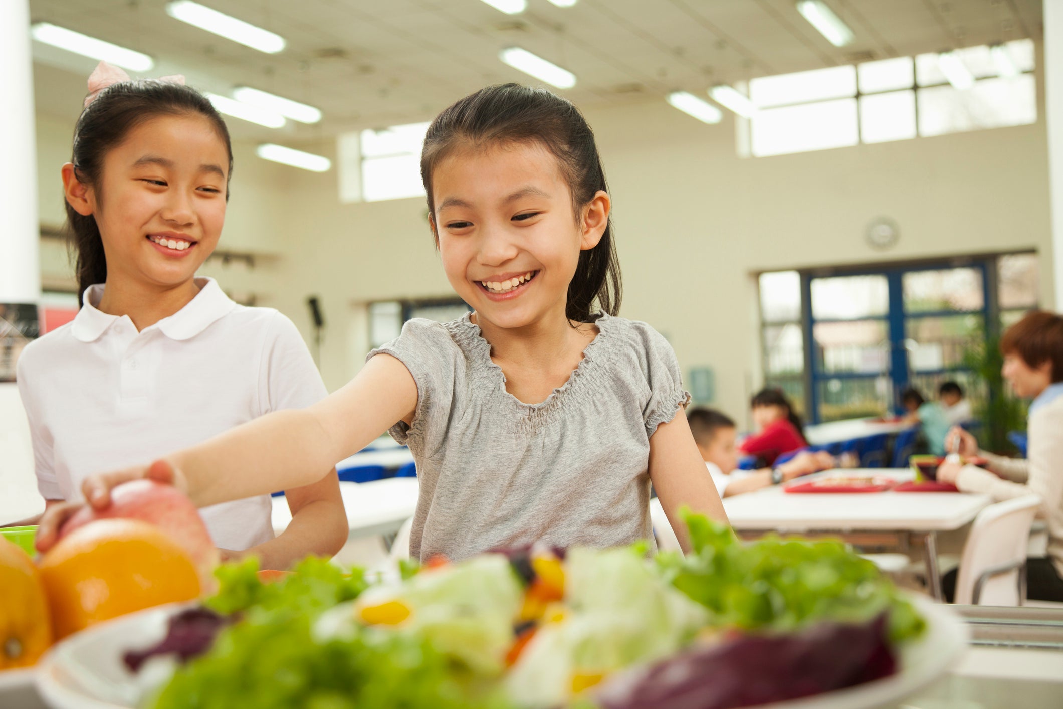 Student reaching for healthy food in cafeteria