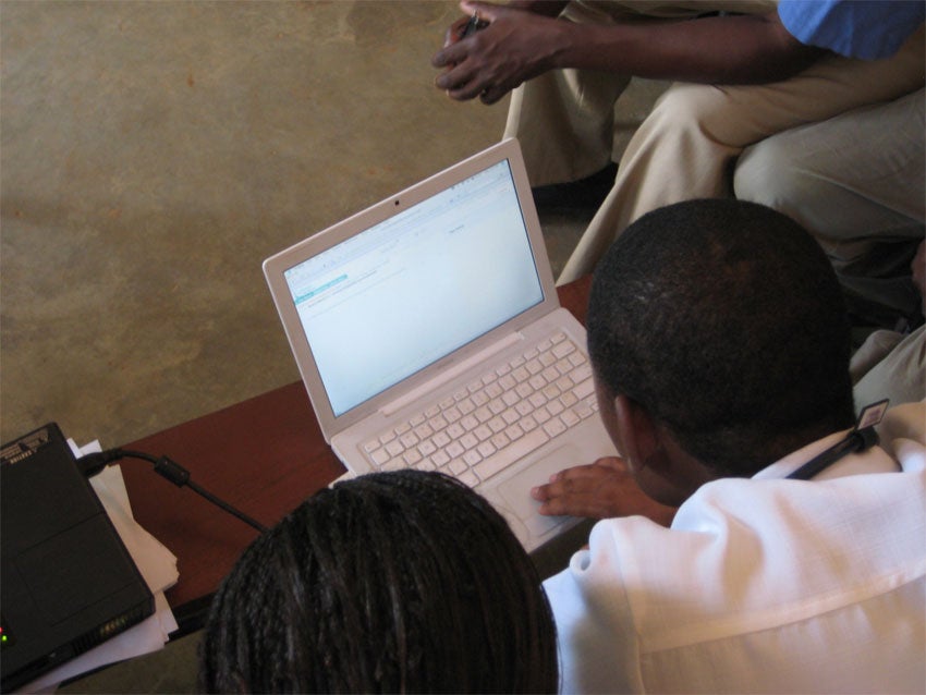 Photo of someone scrolling through an open laptop on a table