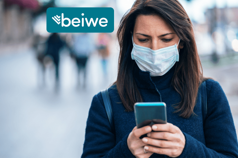 Woman looking at phone. She is wearing a Covid-19 mask.