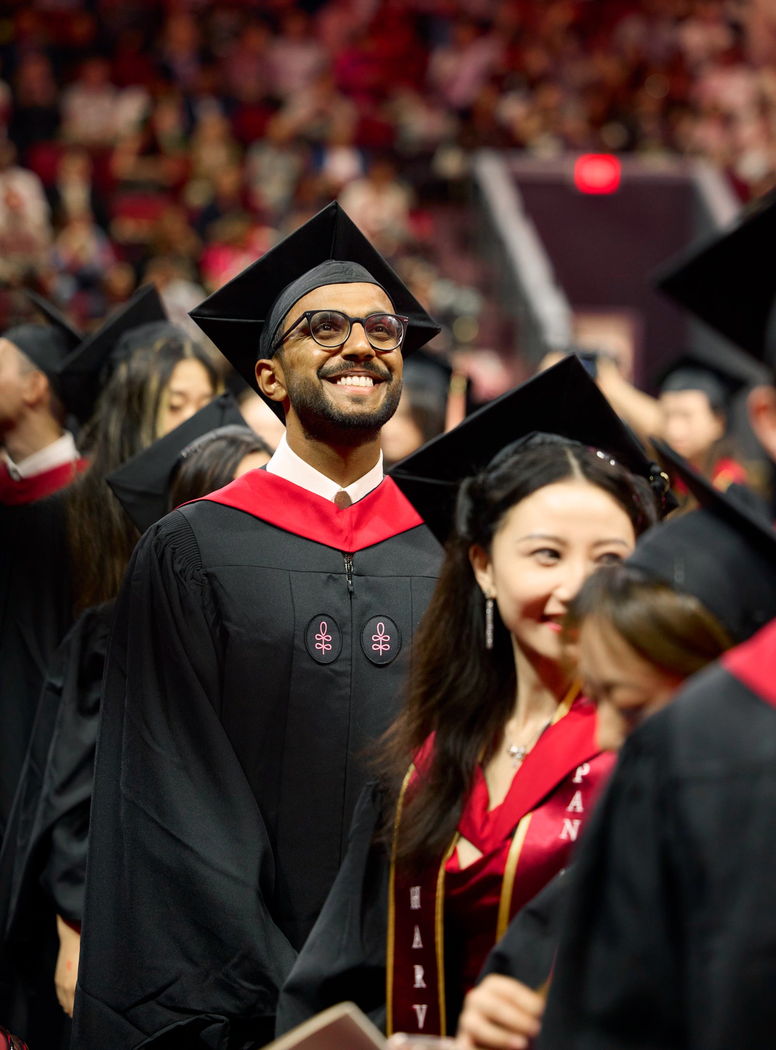 Student stands tall smiling at graduation in Boston