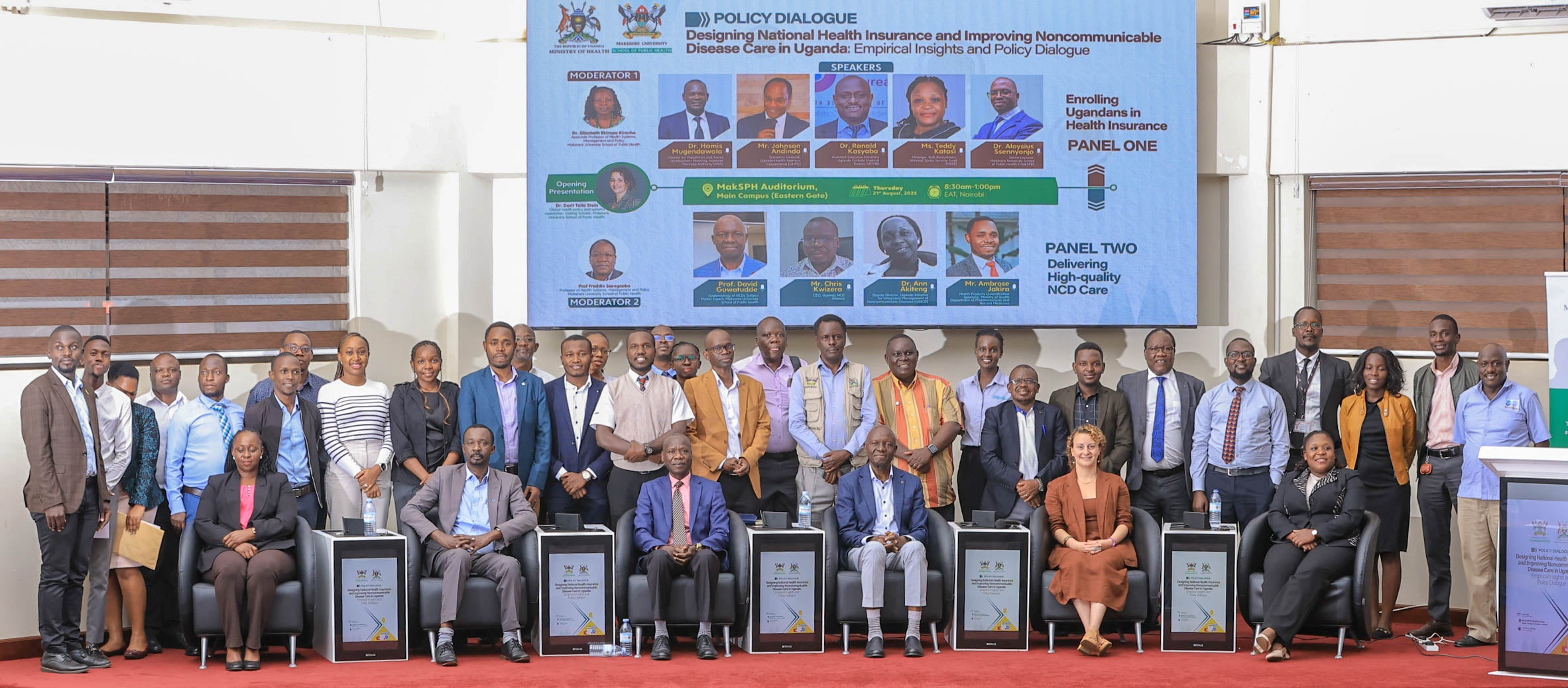 Attendees of the policy dialogue sit and stand together on a stage.