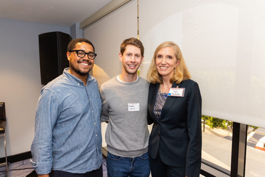 Two young men pose with Kari Nadeau at the LA Wildfire event. 