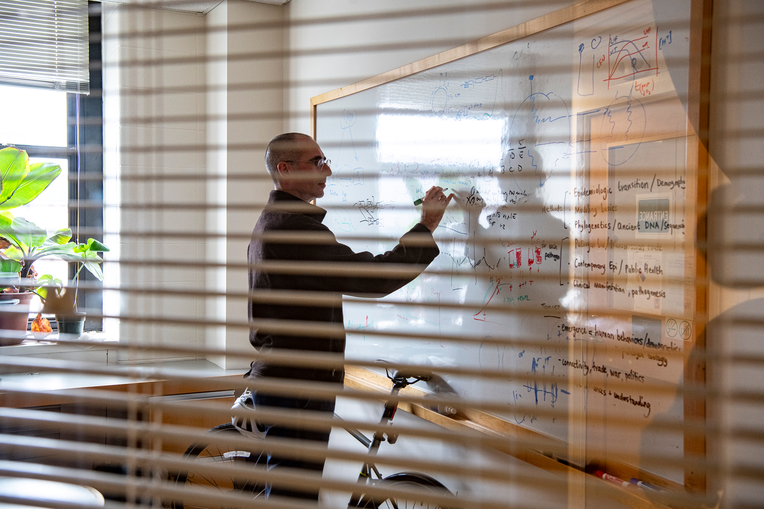 Prof. Yonatan Grad in his office writing on the board