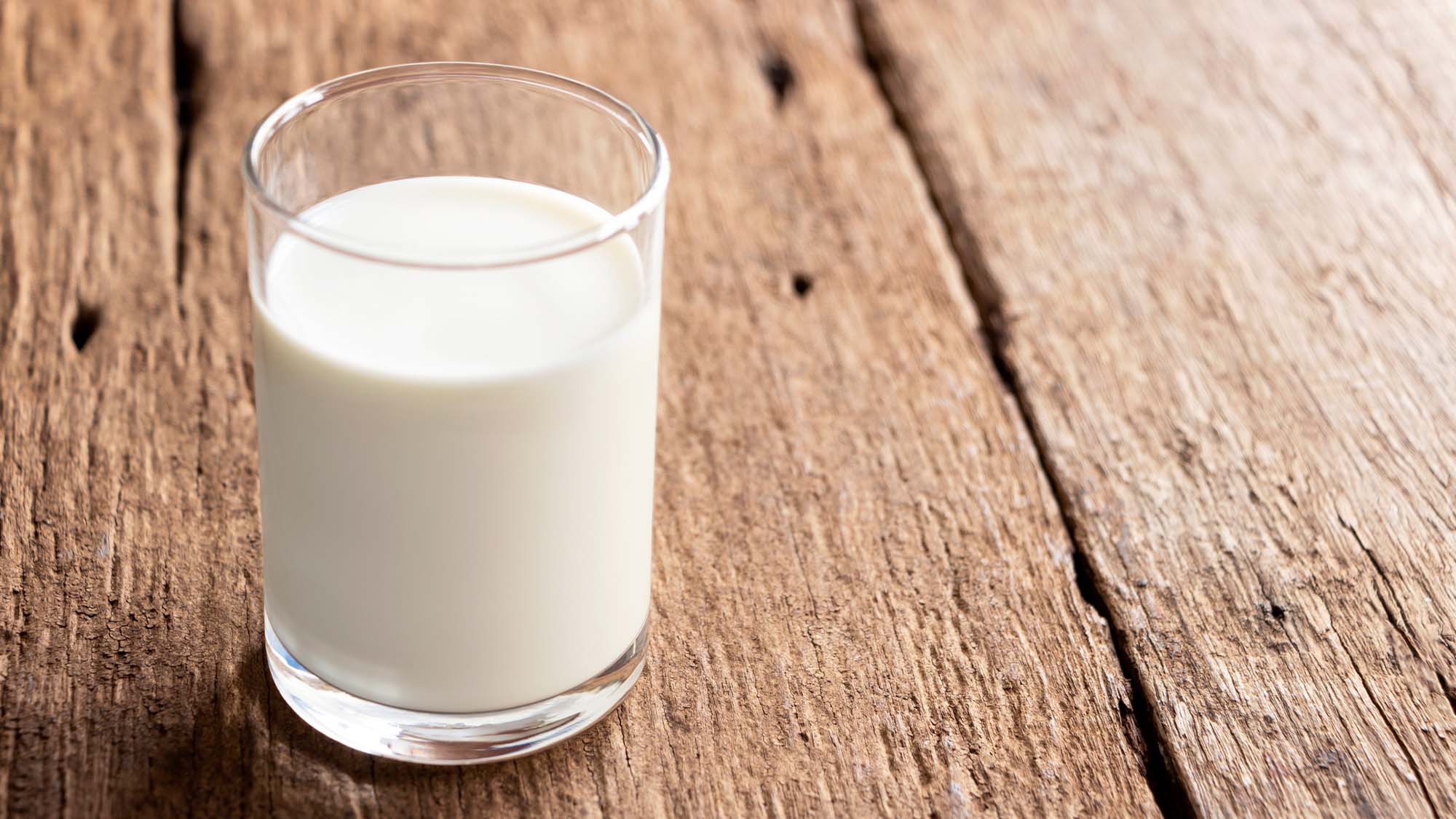 A glass of milk on a table.