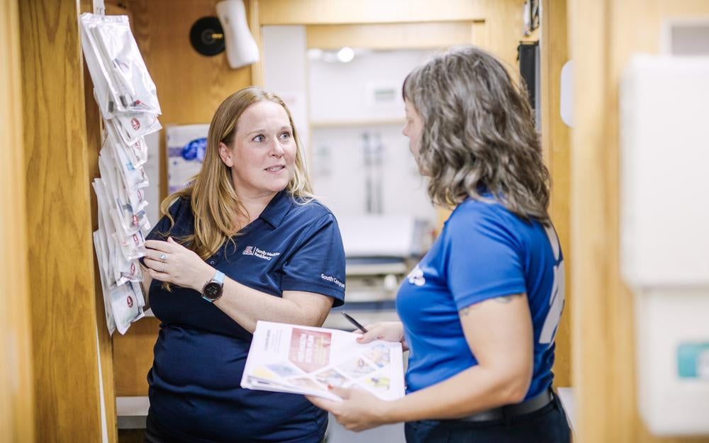 A provider at March of Dimes mobile health clinic in Tucson, Arizona, gives Americares leader a tour of the clinc