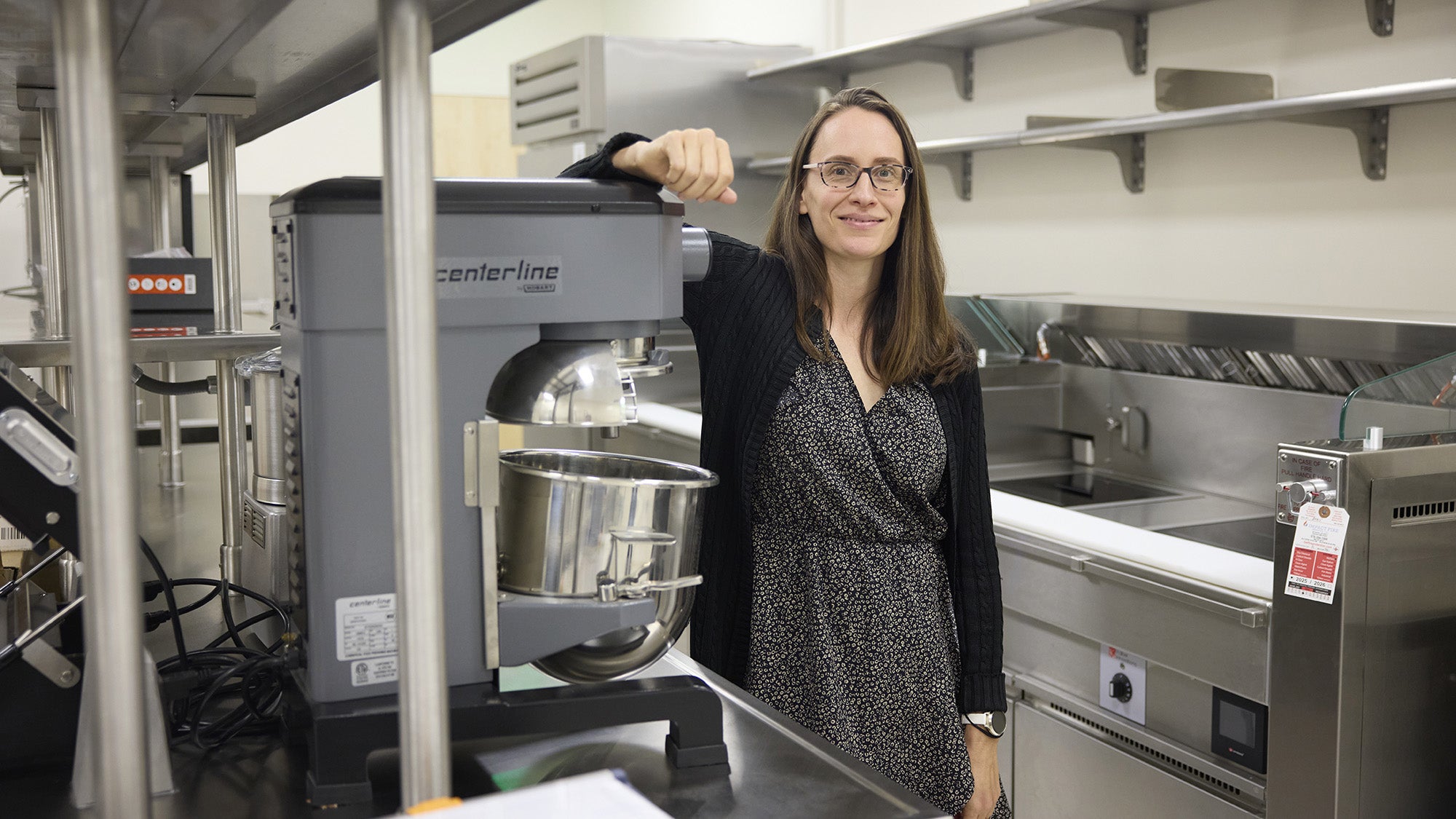 Courtney Peterson standing next to cooking equipment in the Department of Nutrition's research kitchen