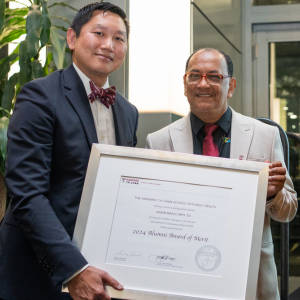 Anthony Chen and Karim Manji hold framed certificate