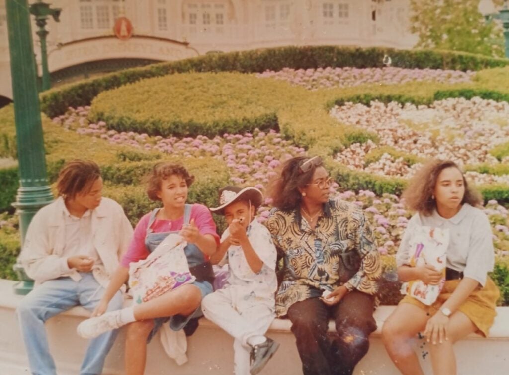 A mom and four kids posing at Disneyland, with the youngest in the middle, dressed as a cowboy.