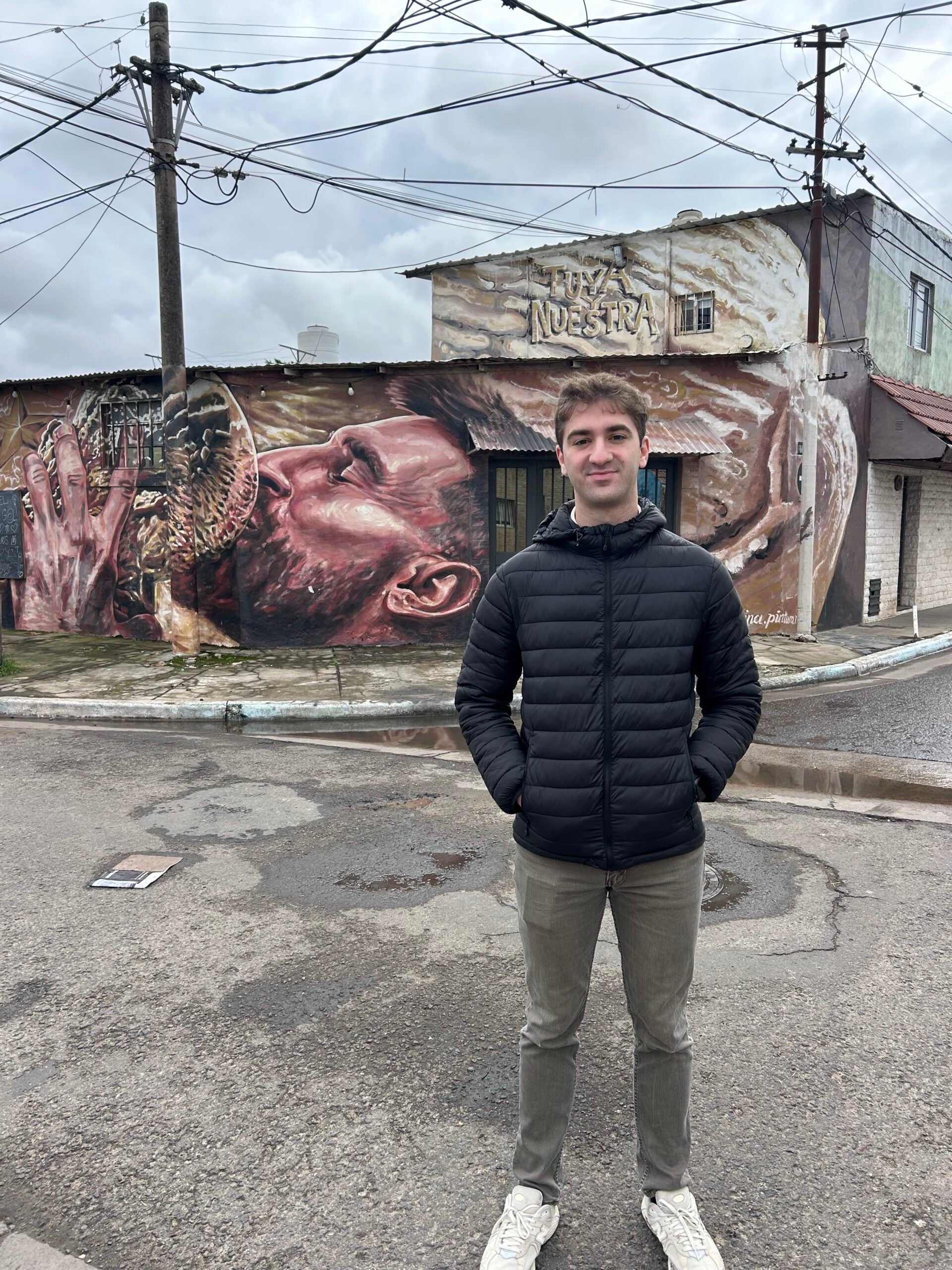 Gene Pozas in front of mural