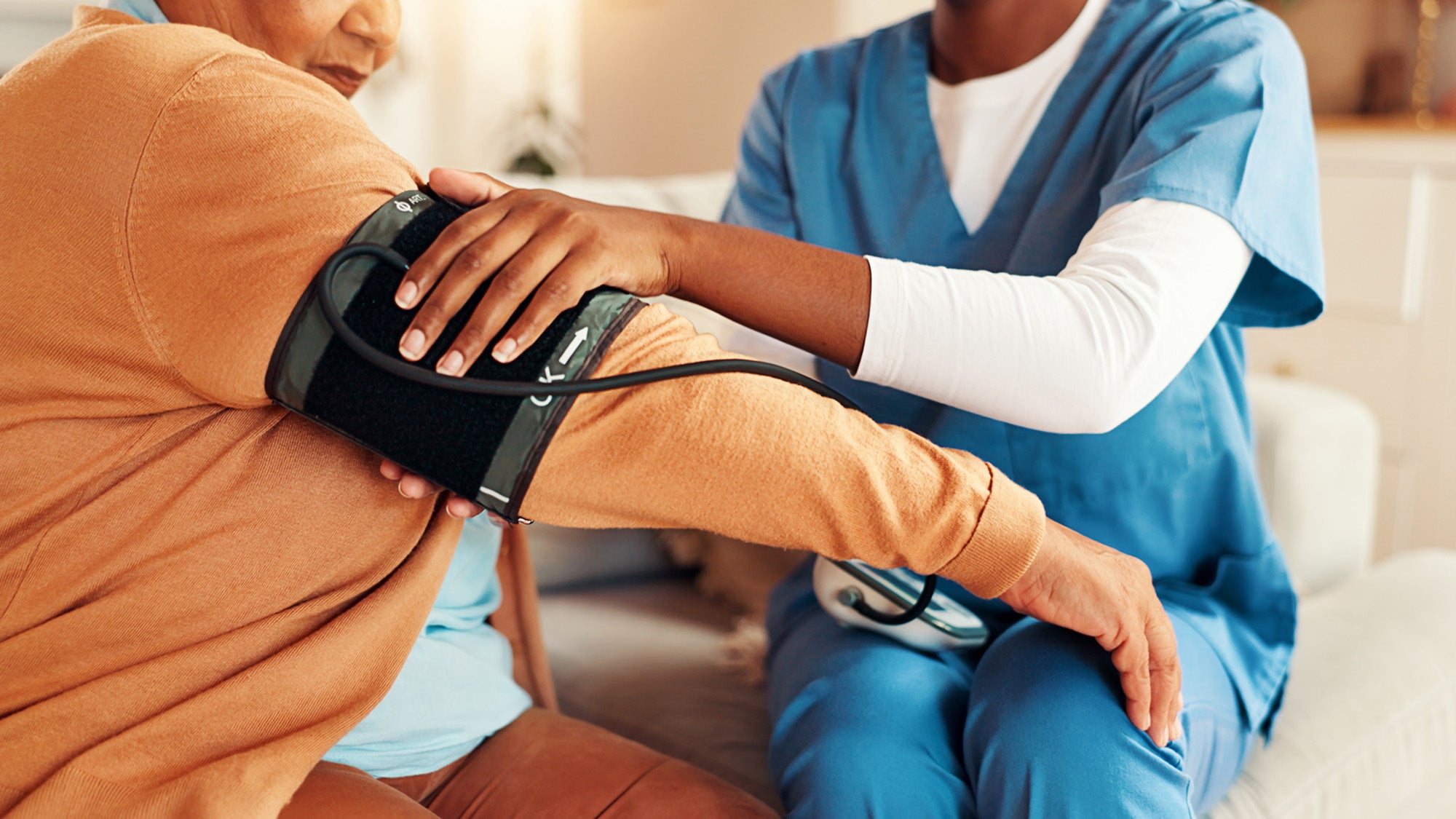 A health worker checks a woman's blood pressure