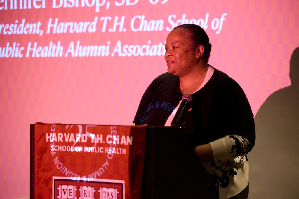 Outgoing Alumni Association President Jen Bishop speaks at the podium. 