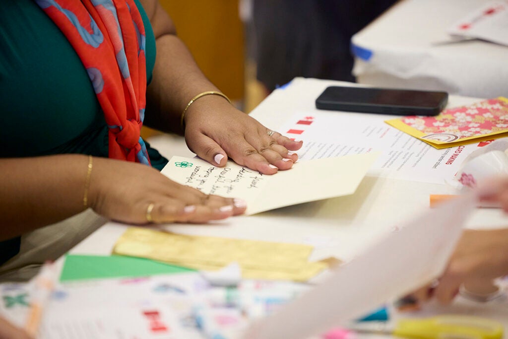 Making cards for seniors. Photo shows a woman's hands on a handwritten card.