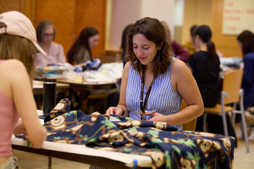 Maddy Kline, a PhD student in infectious disease epidemiology, makes blankets for children in need.