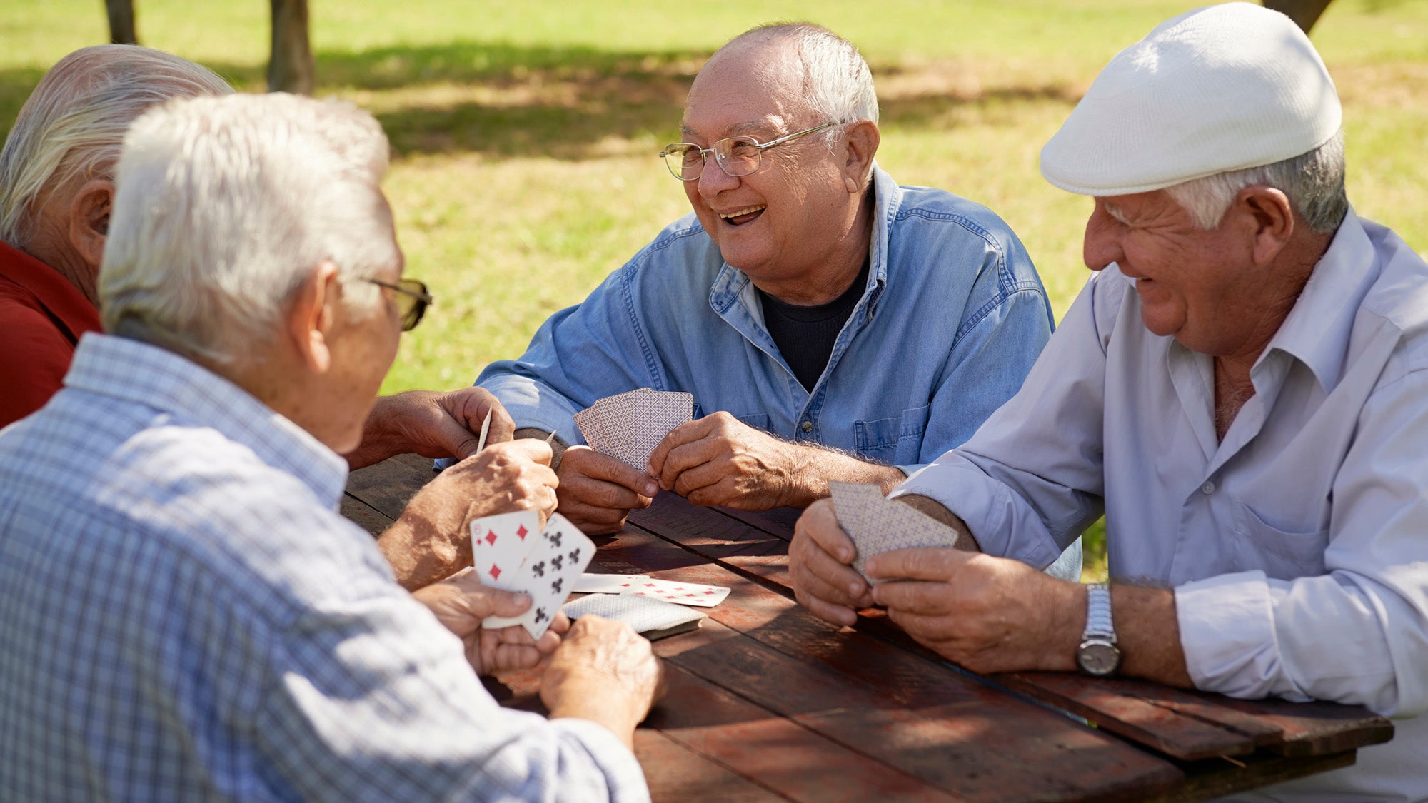 Group of senior men playing cards outdoors