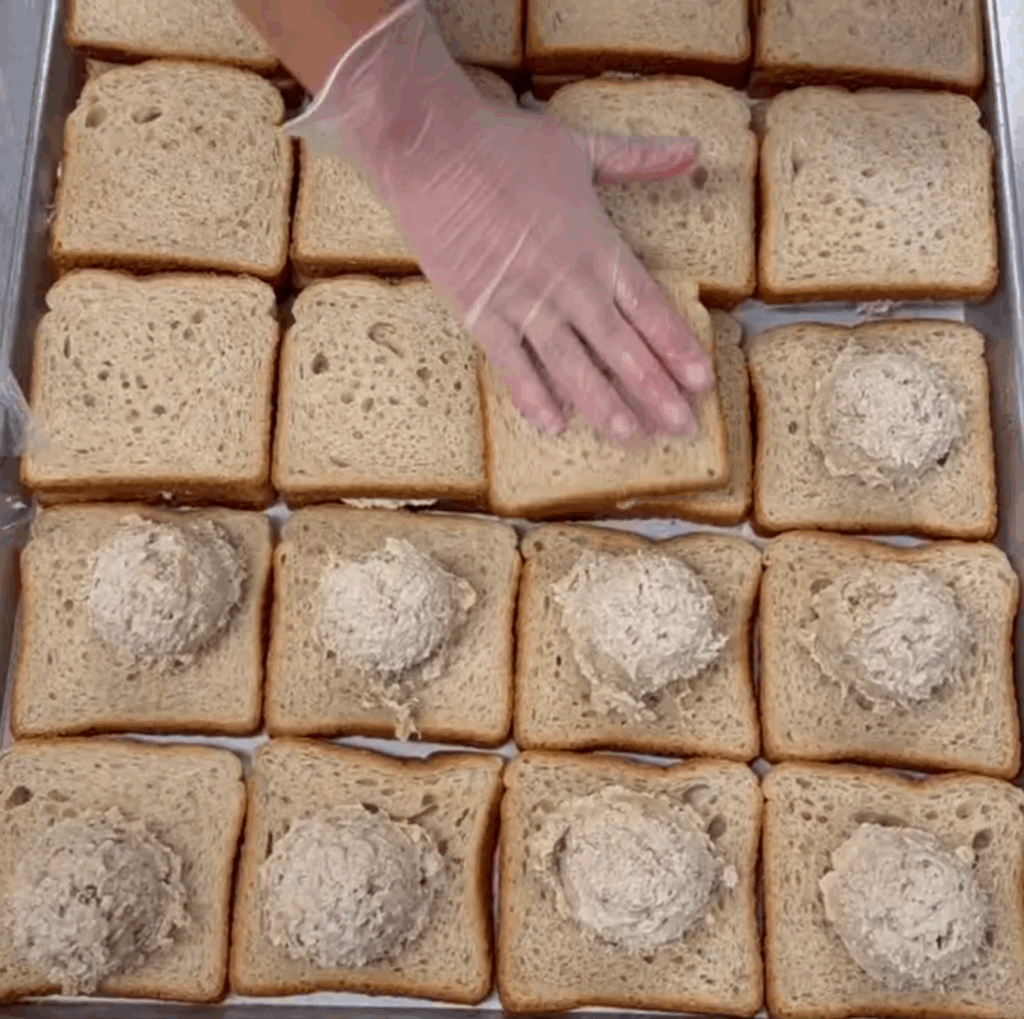 Prepping lunches at Boston's St. Francis House. Photo shows hands putting together a tuna sandwich.