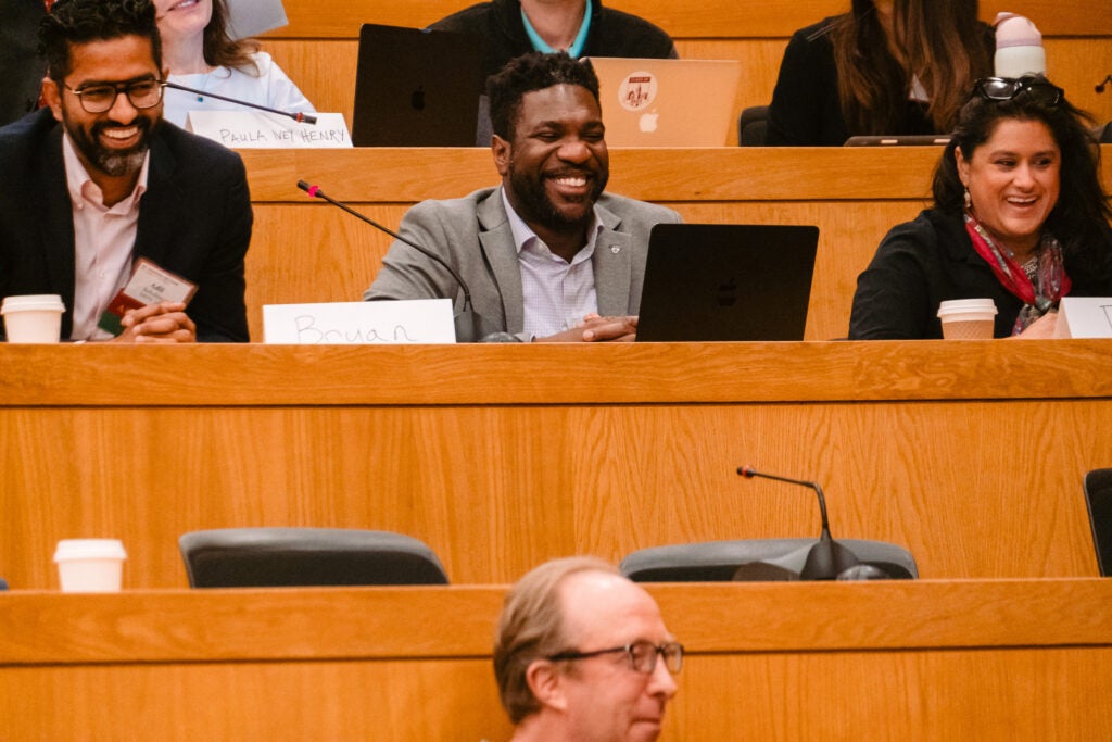 Audience members, including panelist Bryan O. Buckley, laugh. 
