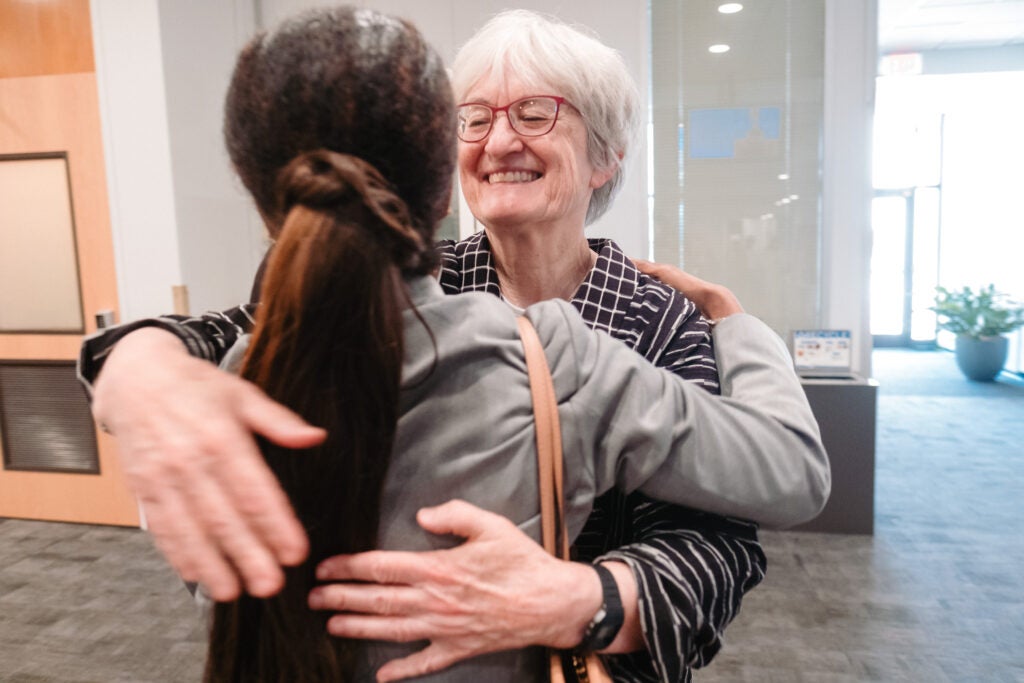 Nancy Turnbull greets an alumna with a hug. 