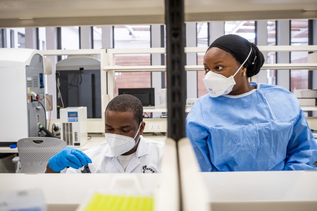 Ayotunde Sijuwola and Ayinla Akeemat Opeyemi, zoonotic research associates at ACEGID, add nucleic acid extracts to a sample in the testing process.