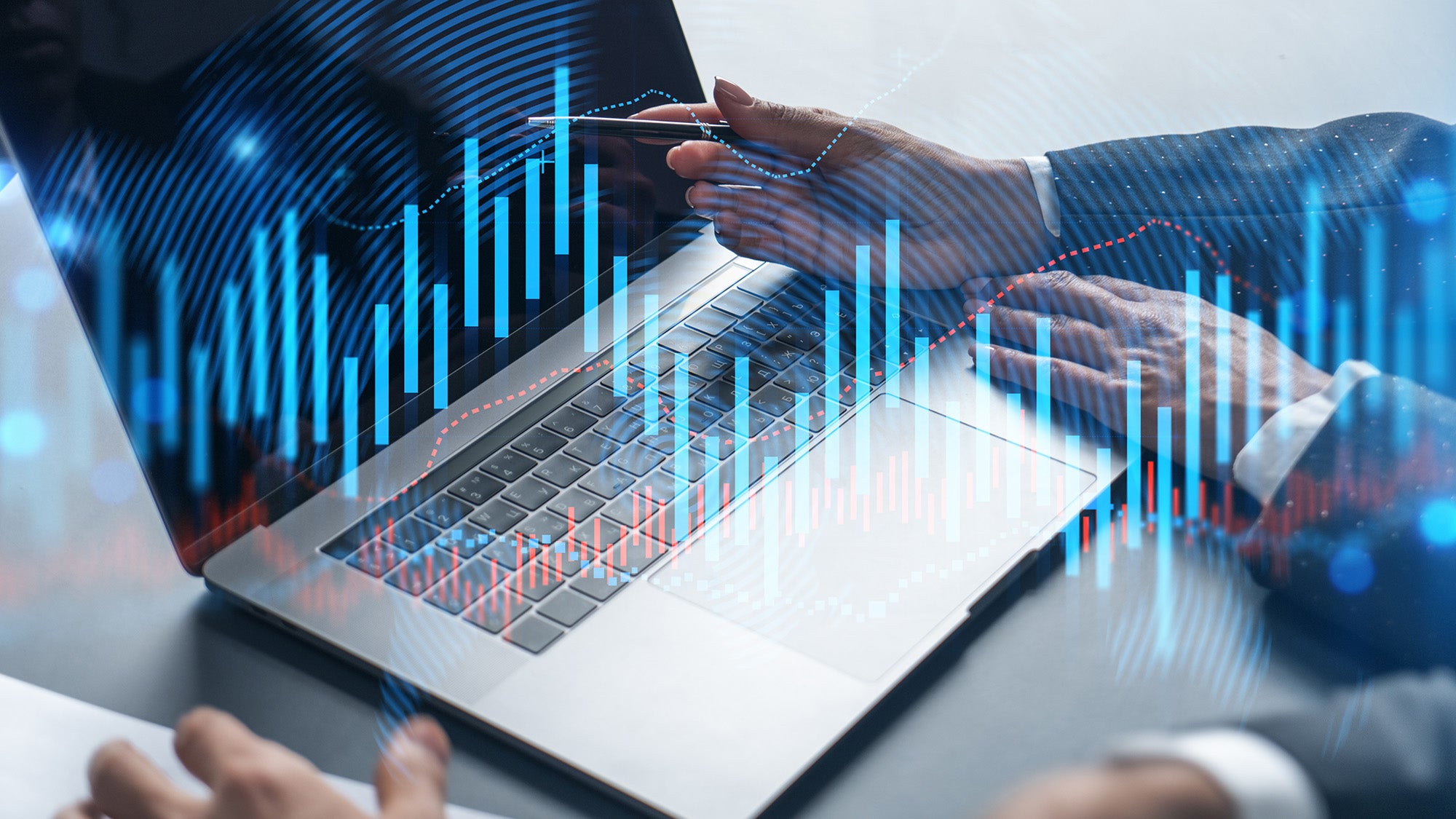 A laptop and the hands of several people looking at it