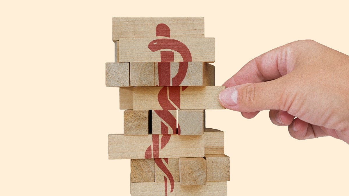 Image of jenga-style pieces with medical caduceus symbol