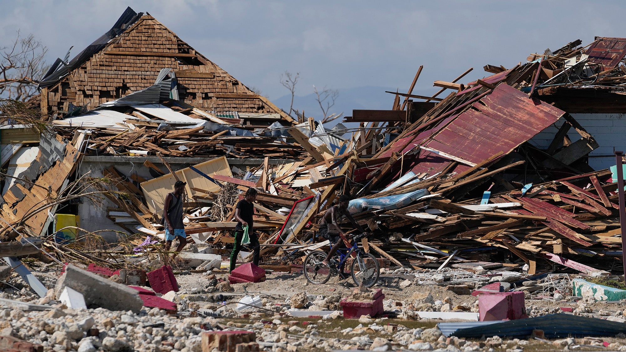 Residents make their way past piles of debris in the aftermath of Hurricane Melissa in Black River, Jamaica, Thursday, Oct. 30, 2025. (AP Photo/Matias Delacroix)