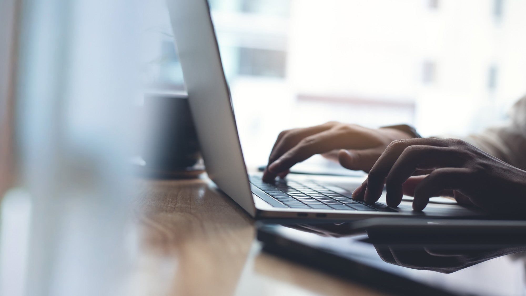 Man hands typing on laptop computer keyboard, close up.