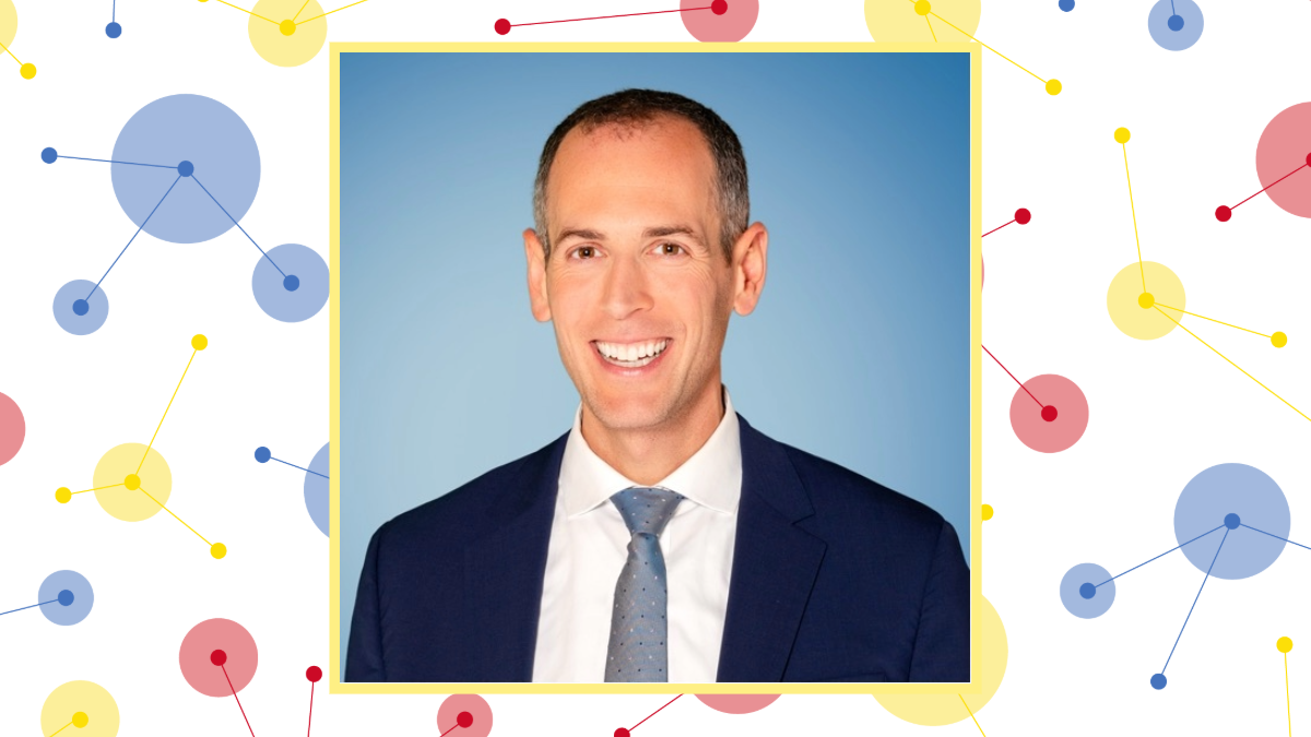 Headshot of Robbie Goldstein on white background with colorful dots