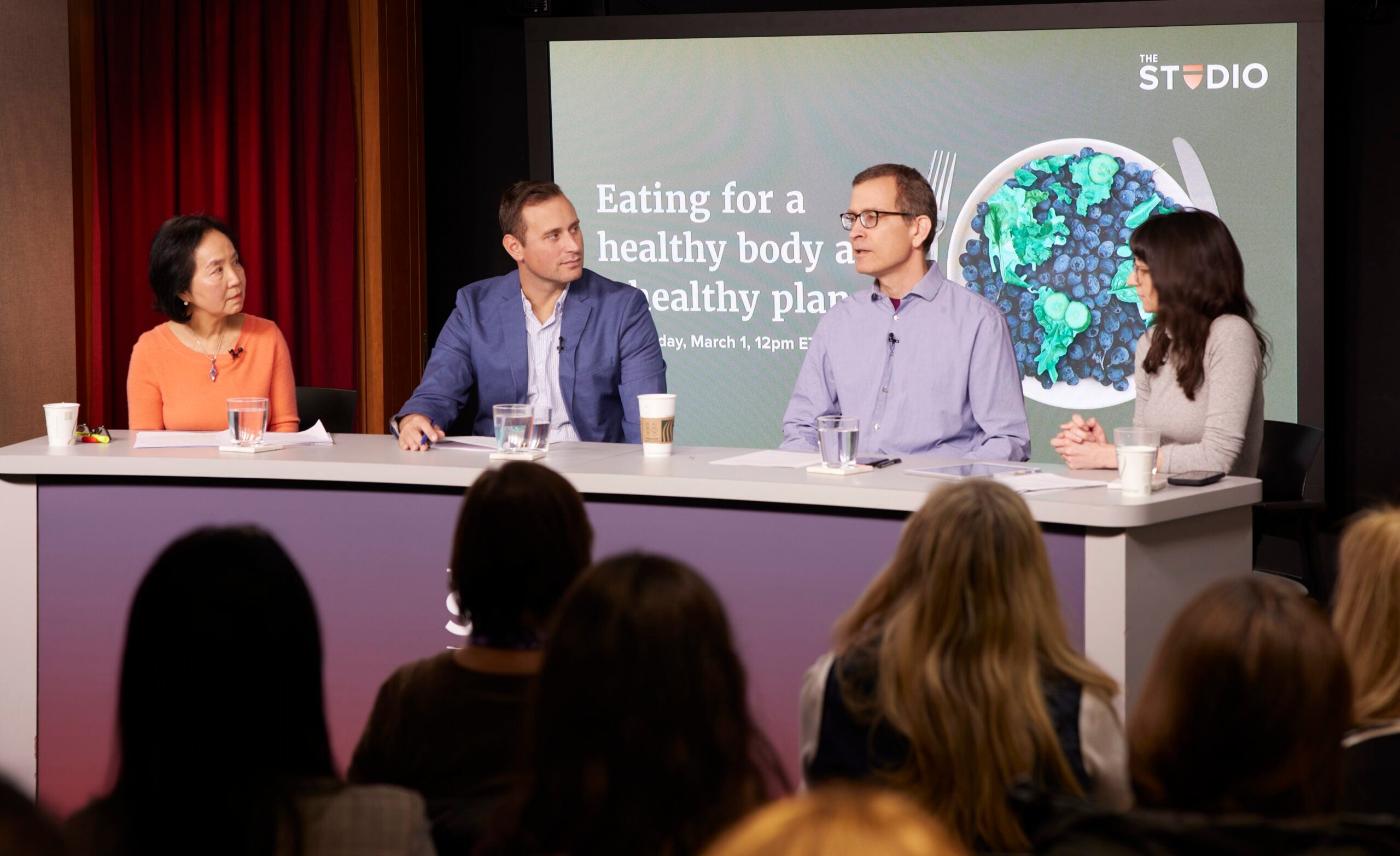 a group of panelists at a studio event