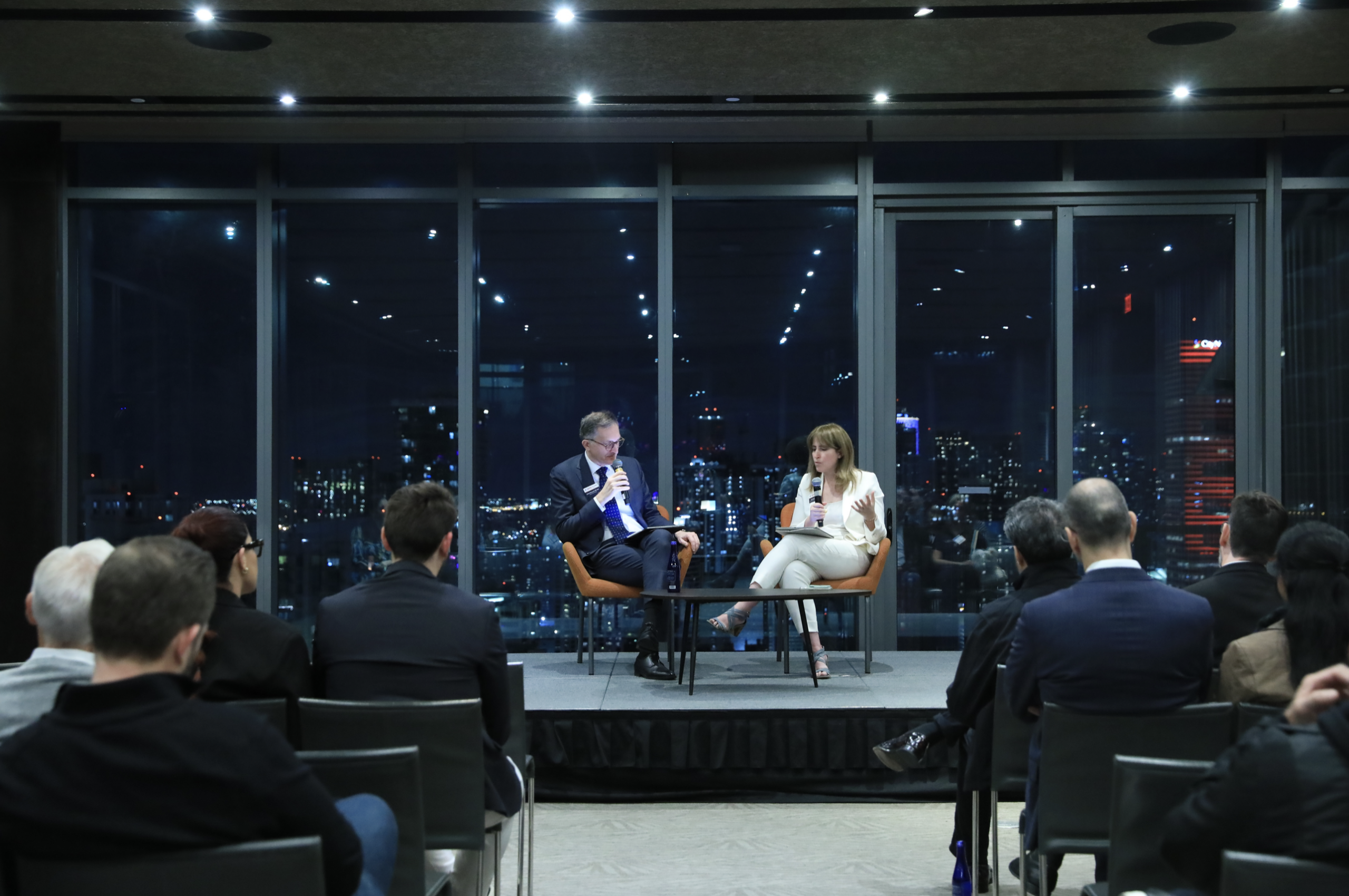 Dean Andrea Baccarelli and lecturer and center director Amanda Yarnell speaking on stage as audience observes.
