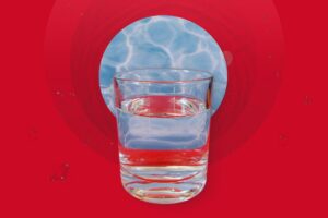 An illustration of a glass of water superimposed over a cancer cell against a red background.