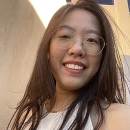 a headshot of Jintong Zhao, biostatistician. she wears oval glasses and smiles at the camera. her dark brown hair is shoulder-length and she is wearing a white top.