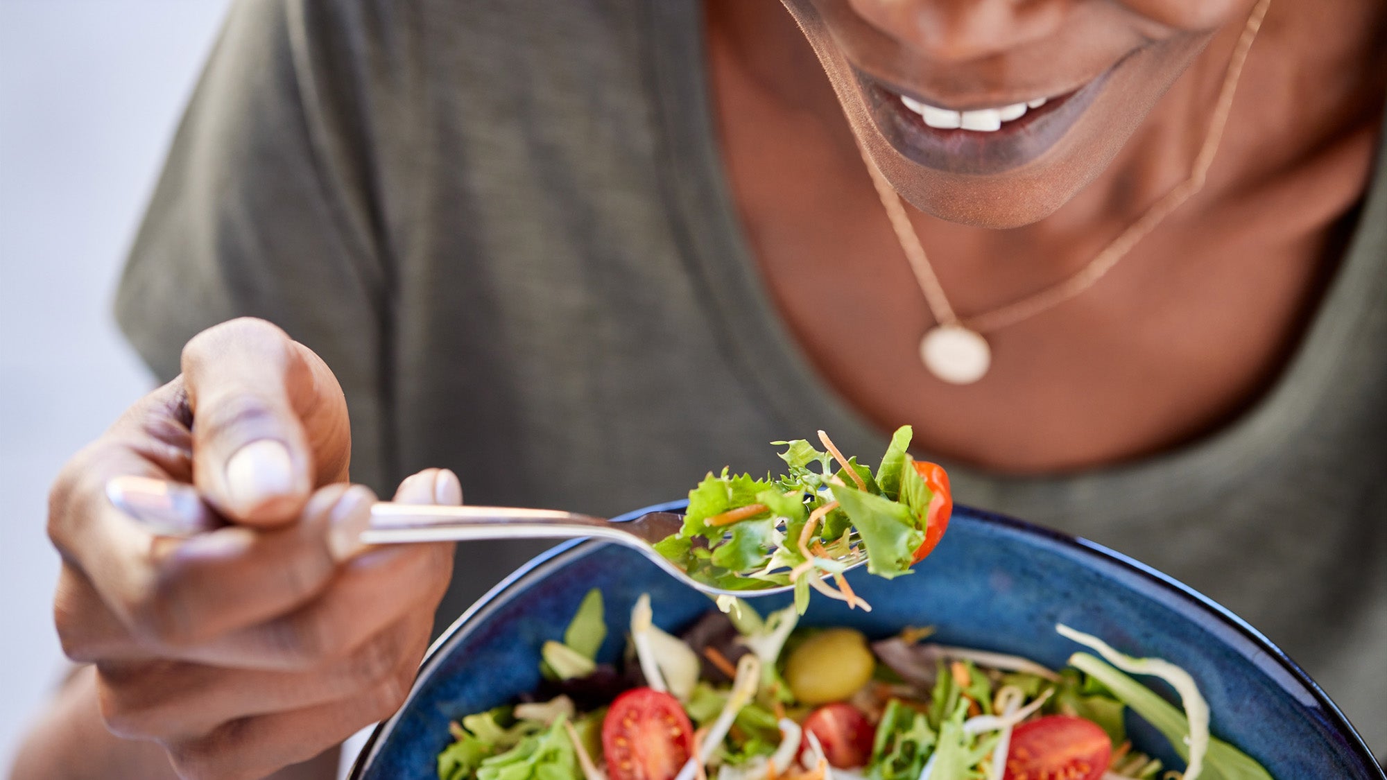 close up of a woman eating salad