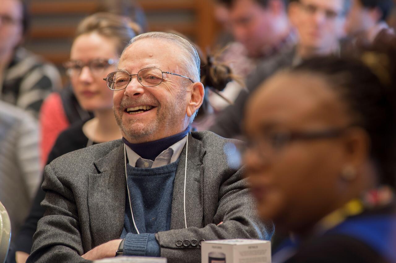 Barry Bloom laughing in a lecture hall surrounded by peers