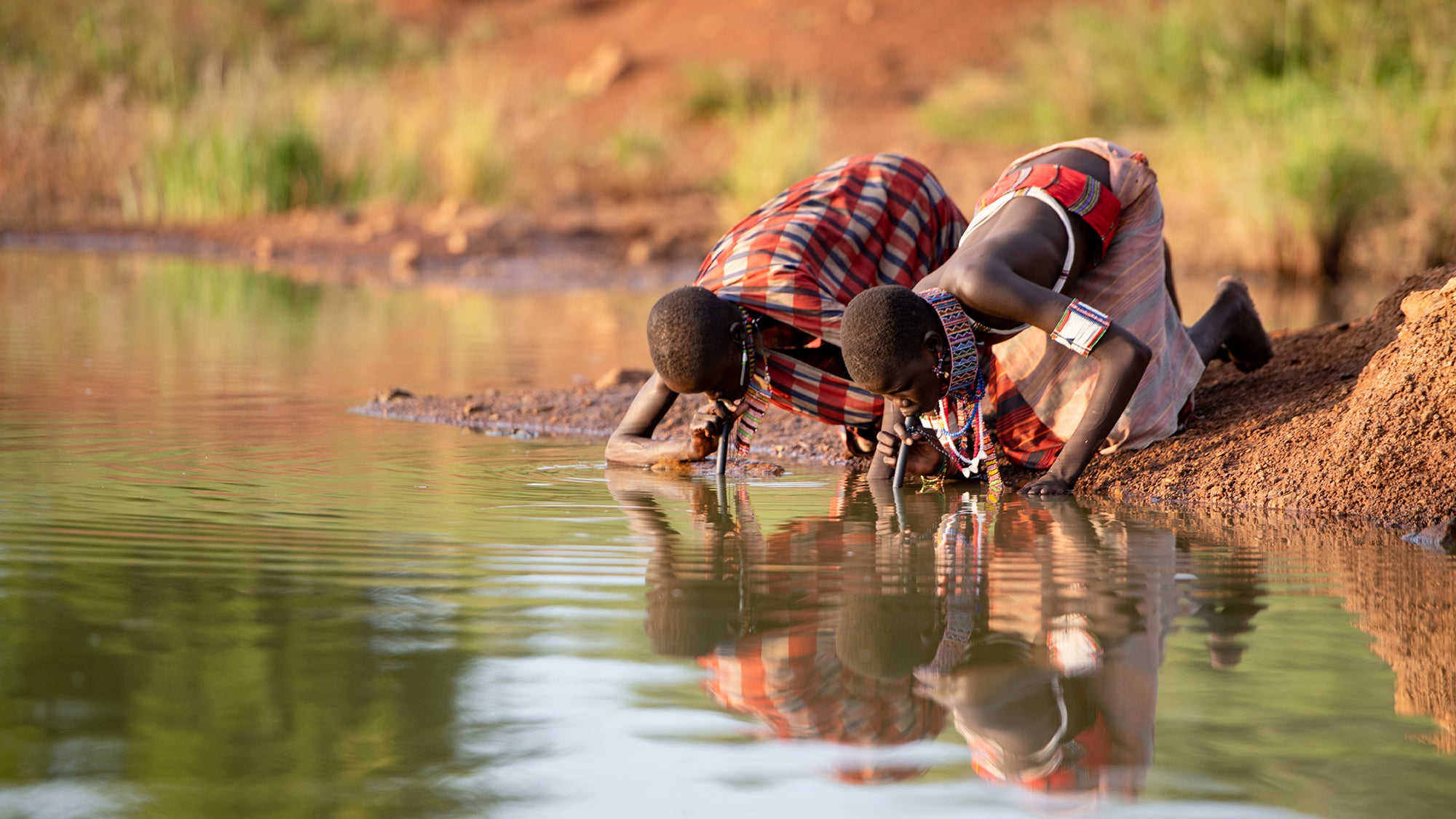 People drinking water through filter pipes