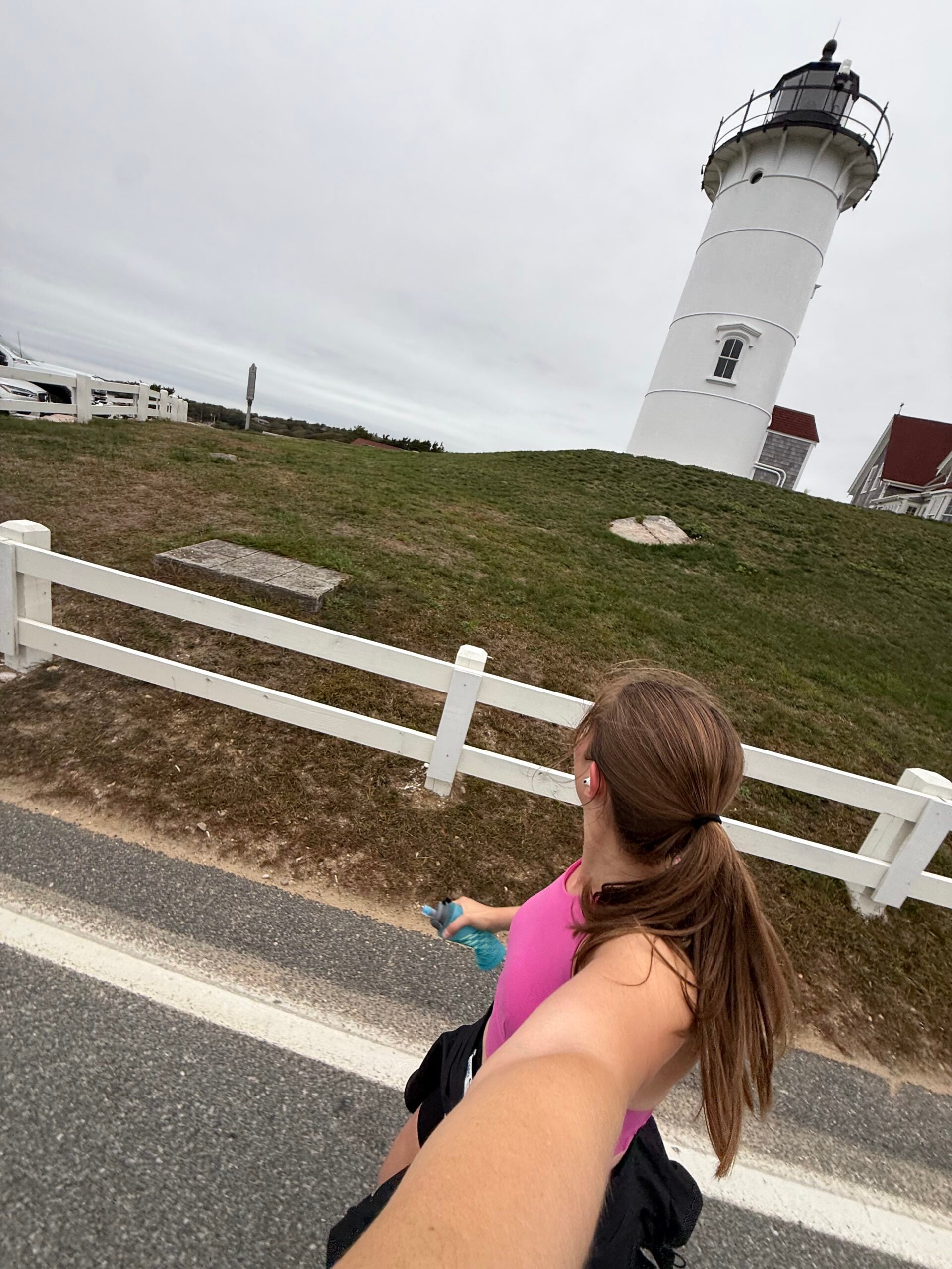 Hanna Matthews running by a lighthouse in Cape Cod.