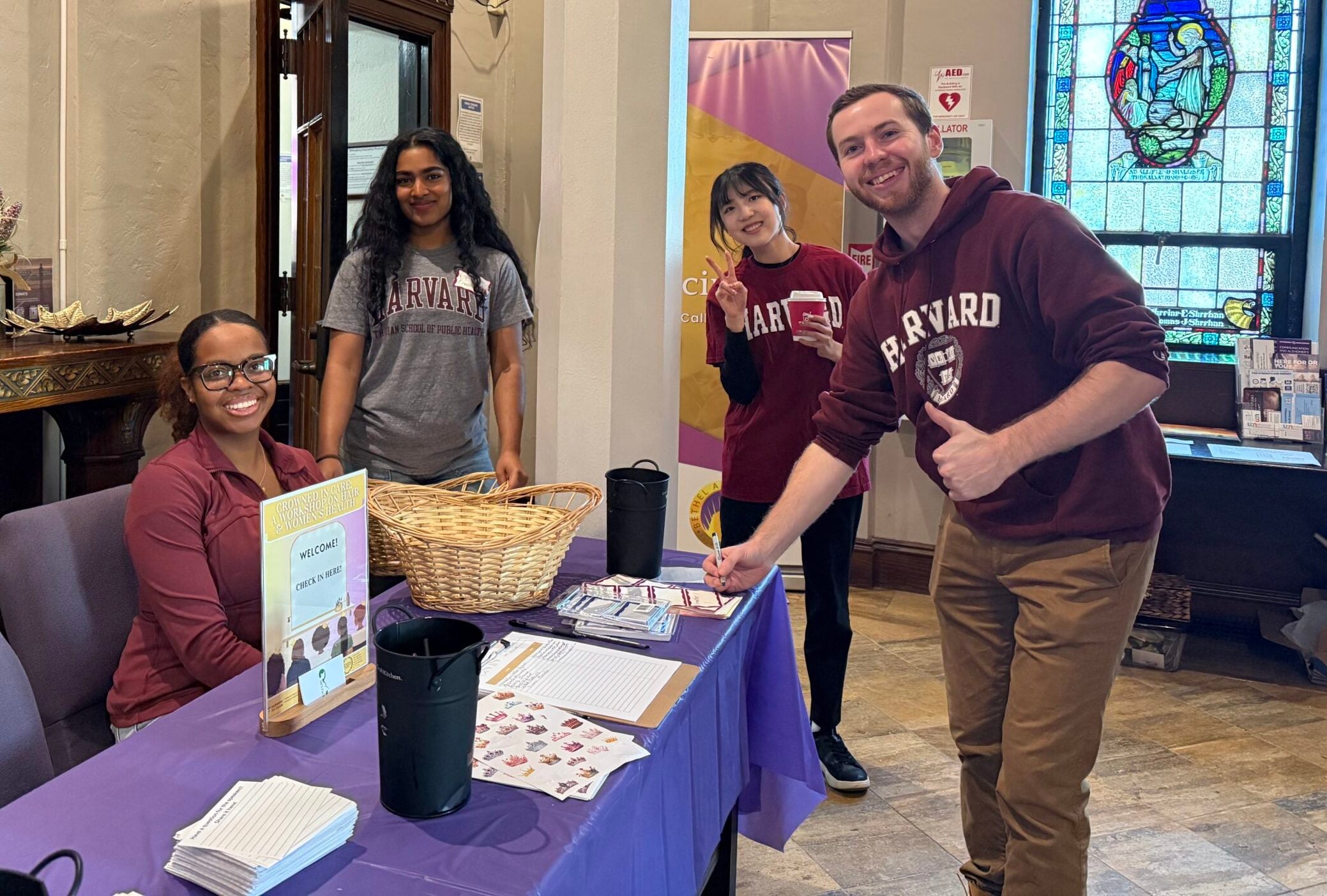 Student volunteers (left to right) Jaylyn Senise, Chathrini Kularatne, Eihi Yoshinaga, and Ben Lanava at the Crowned in Care registration table.