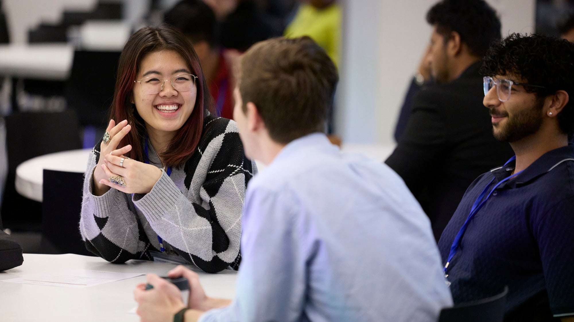 A smiling woman engaged in conversation with her teammates