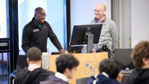 Two men stand by a computer screen