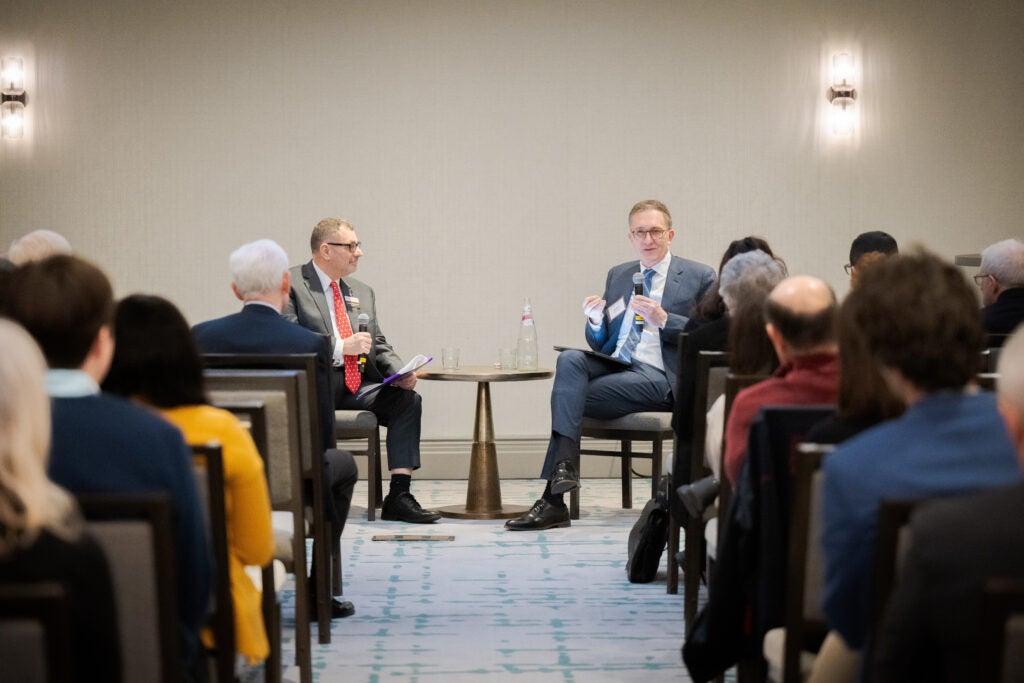 Full rows look on as Dean Baccarelli speaks to the audience, while Dr. Massoud looks on. 